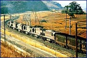Rear end, 200-wagon train: Diesel-electric distributed power remote locomotive consist on heavy rail track infrastructure and overhead traction equipment.